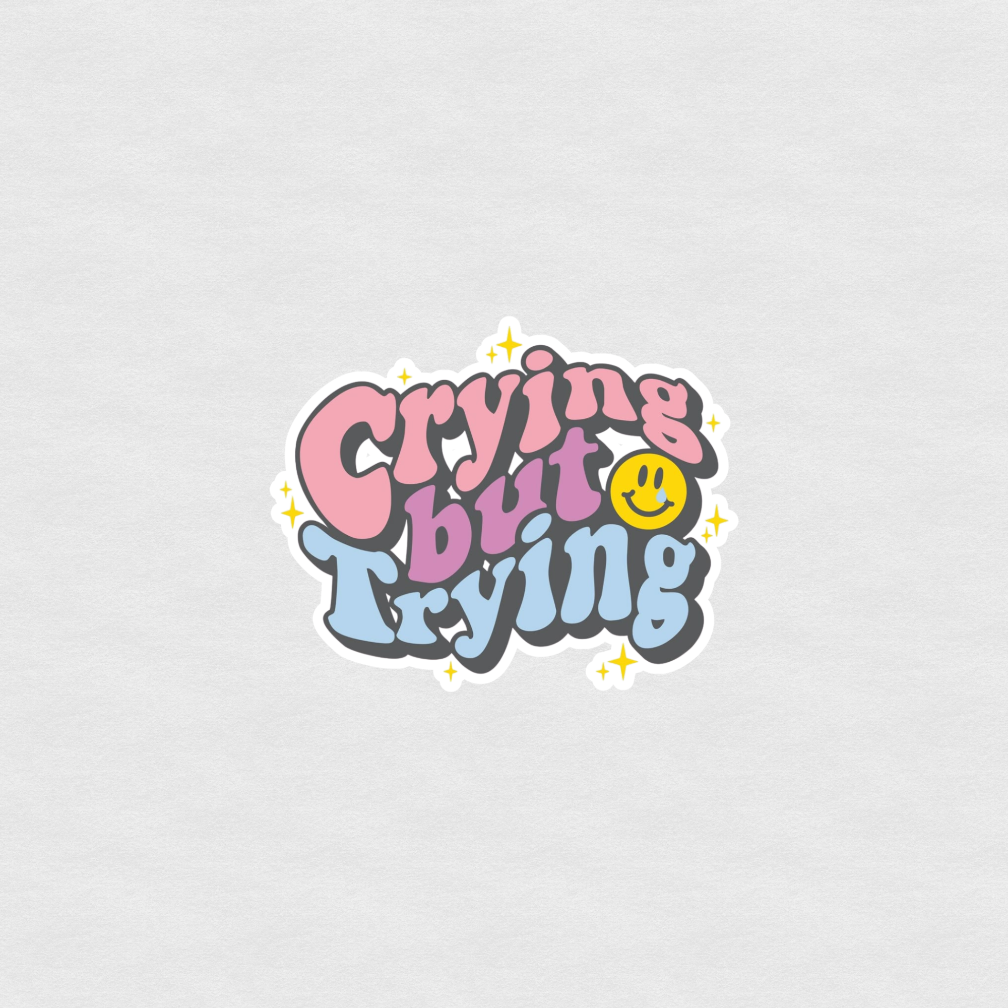Colorful “Crying but Trying” sticker with smiley face and retro bubble lettering
