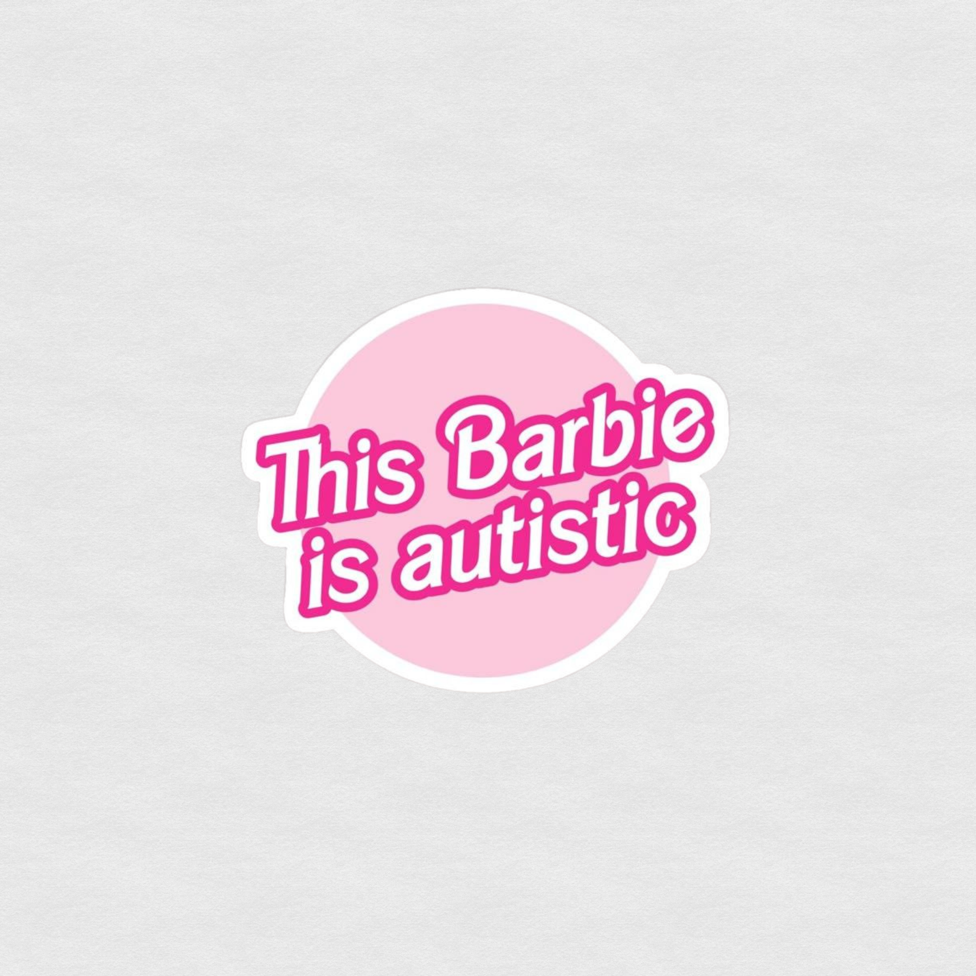 Pink circle sticker reading “This Barbie is autistic” in bold Barbie-inspired lettering
