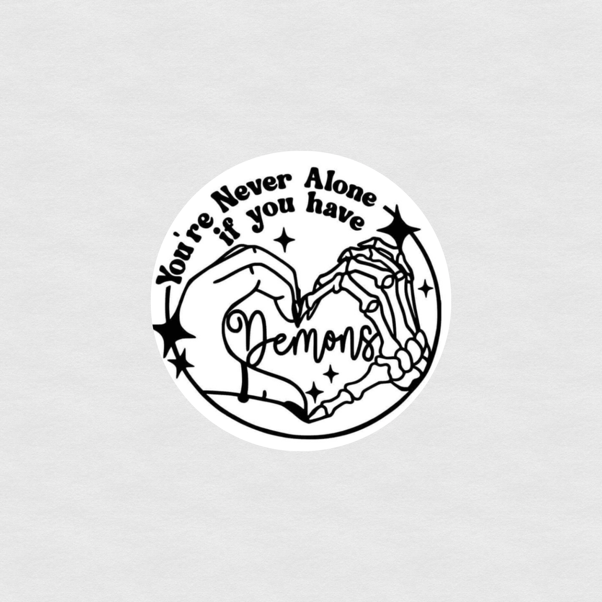 Black and white sticker of skeleton and human hands forming a heart with text “You’re never alone if you have demons”